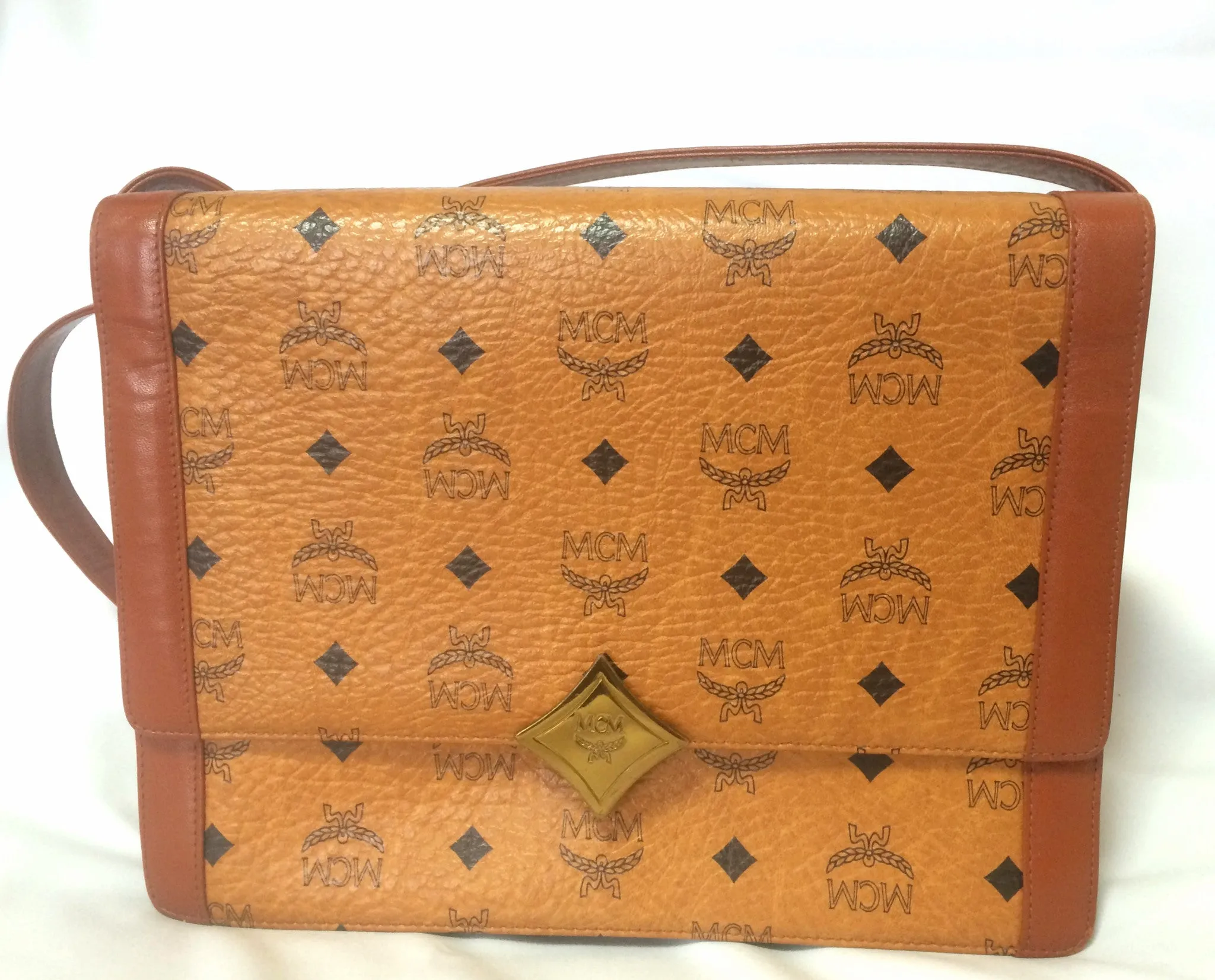 Vintage MCM brown monogram shoulder bag with leather straps and golden star shape logo motif closure. Designed by Michael Cromer. 060621r1